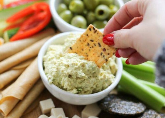 dipping cracker in Toby's plant based dip & spread